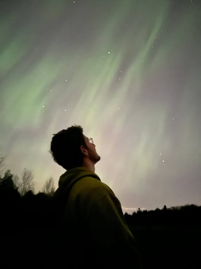 Quentin seen from behind under the northern lights