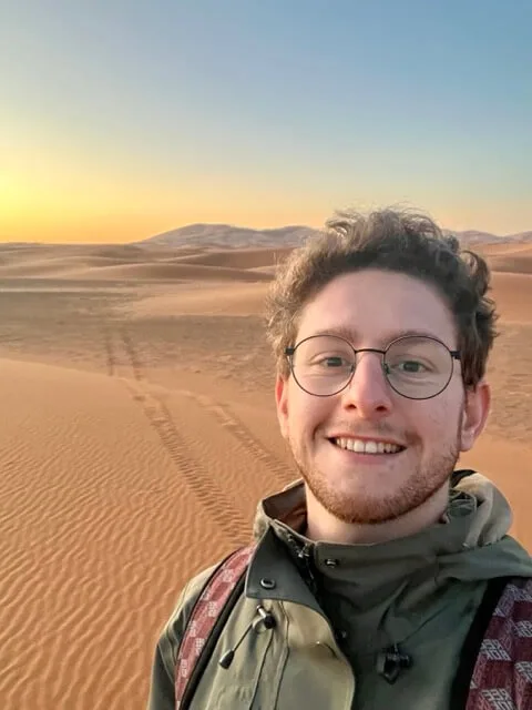 Quentin smiling in the desert at sunset